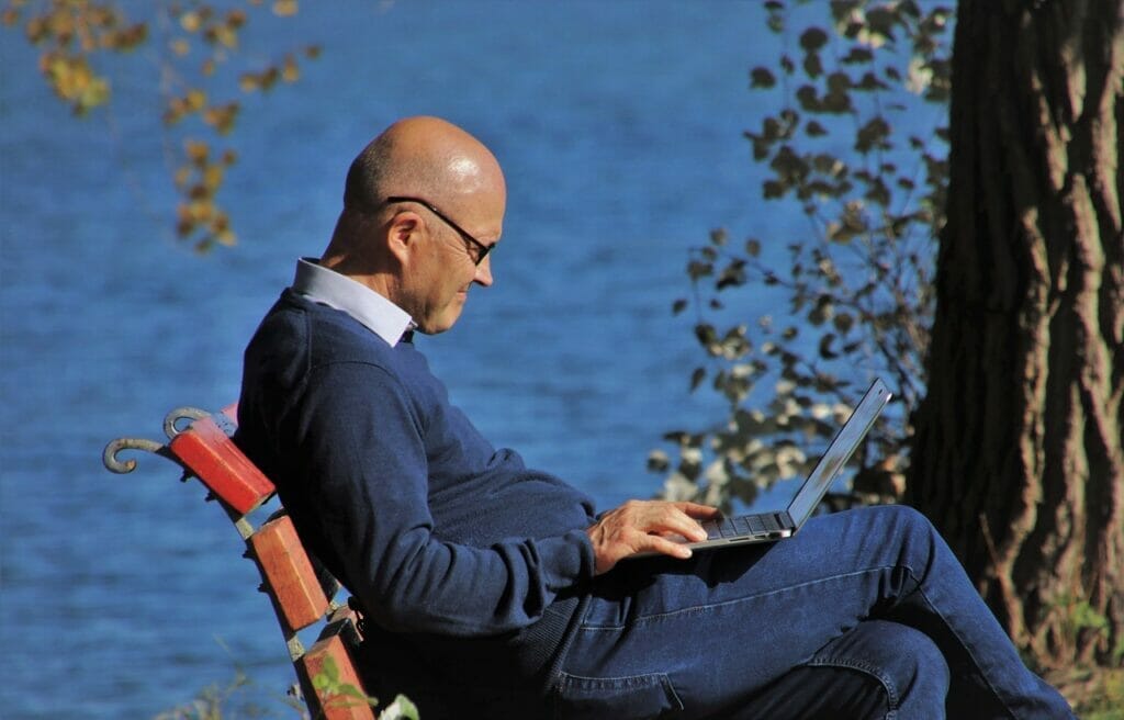 Smiling Middle-Aged Expat with Laptop in Park - English-Speaking Services for Communication and retirement in Germany