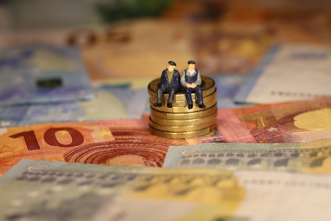 Two elderly individuals seated on a pile of money, symbolizing voluntary contributions to the German pension scheme, highlighting financial security in retirement